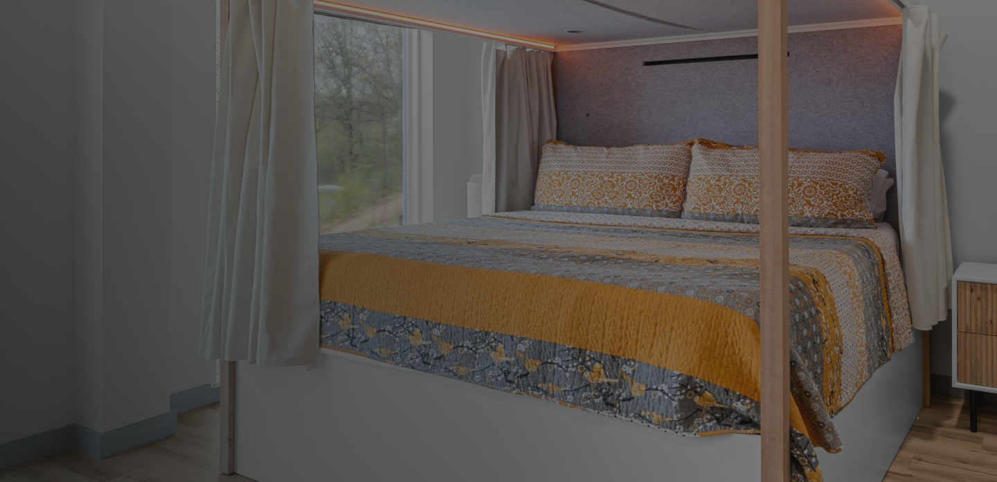 Rediscover Rest - Canopy Sleep in Oak with orange lighting and darkening shades drawn